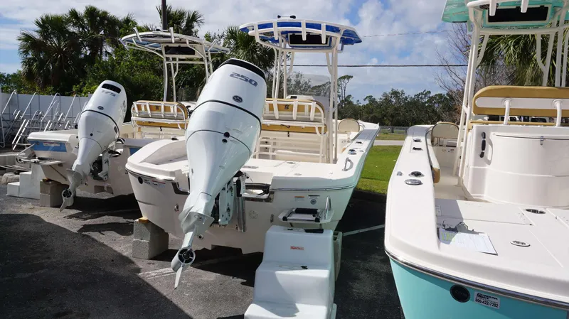 Slide: The Image of 2023 Carolina Skiff 24 Ultra Elite boats with powerful outboard motors, parked outdoors. - 13