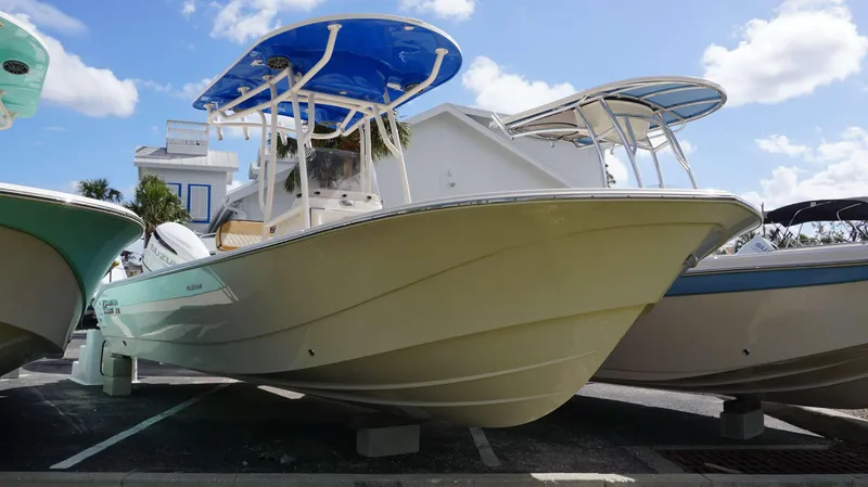 Slide: The Image of 2023 Carolina Skiff 24 Ultra Elite boat displayed outdoors under blue sky. - 2