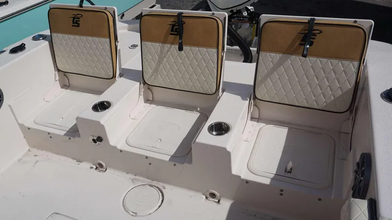 Slide: The Image of 2023 Carolina Skiff 24 Ultra Elite boat seating with cup holders and storage compartments. - 3