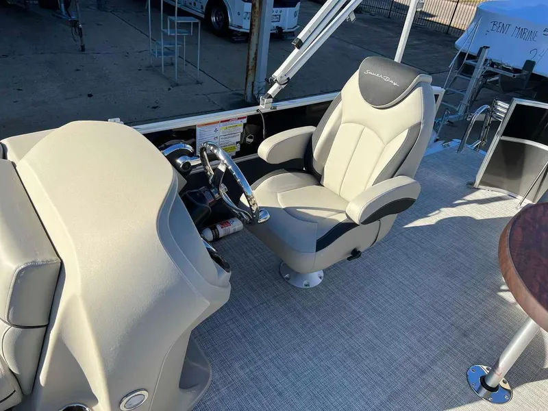 Slide: The Image of Captain's chair and helm of a 2023 South Bay 220CR LE 2.0 pontoon boat. - 6