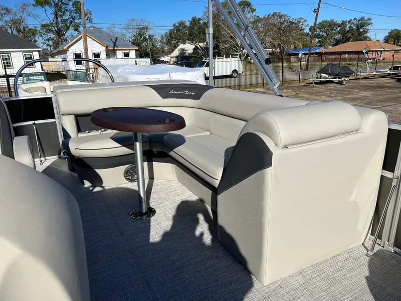 Slide: The Image of 2023 South Bay 220CR LE 2.0 pontoon boat interior with beige seating and round table. - 7