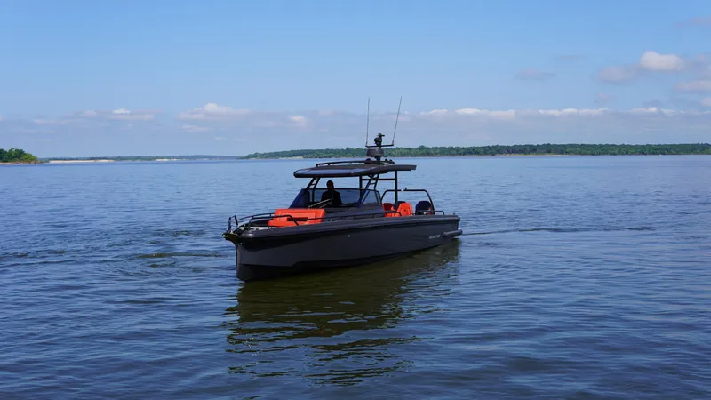 Slide: The Image of 2020 BRABUS Shadow 900 Sun Top boat cruising on a calm lake under a clear blue sky. - 12