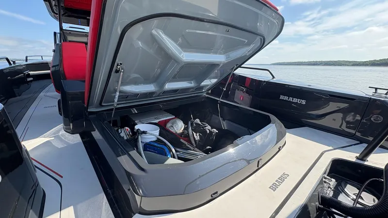 Slide: The Image of 2020 BRABUS Shadow 900 Sun Top boat with open storage compartment, docked by the water. - 39