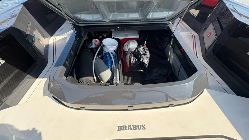 Slide: The Image of Storage compartment of 2020 BRABUS Shadow 900 Sun Top boat, open with various items inside. - 40