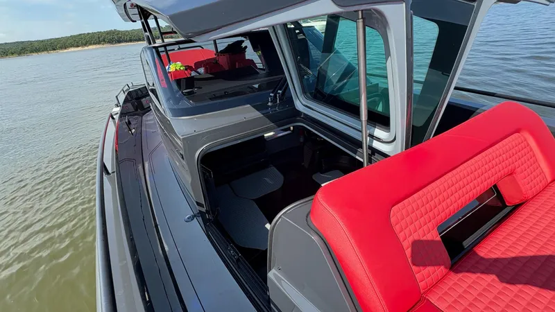 Slide: The Image of 2020 BRABUS Shadow 900 Sun Top with red seating on a calm lake. - 47
