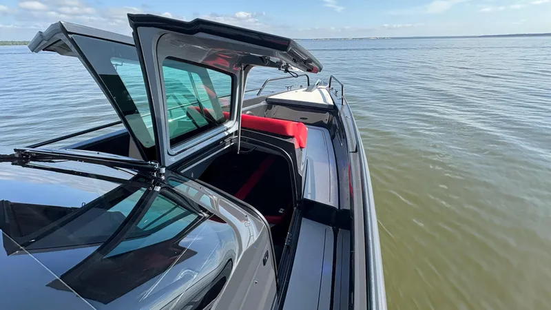 Slide: The Image of 2020 BRABUS Shadow 900 Sun Top boat on calm water, featuring sleek design and open sunroof. - 48