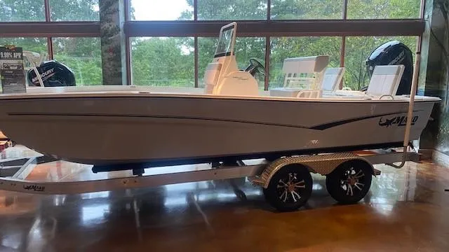 The Image of 2023 Mako Pro Skiff 19 CC boat on a trailer in a showroom. - 0