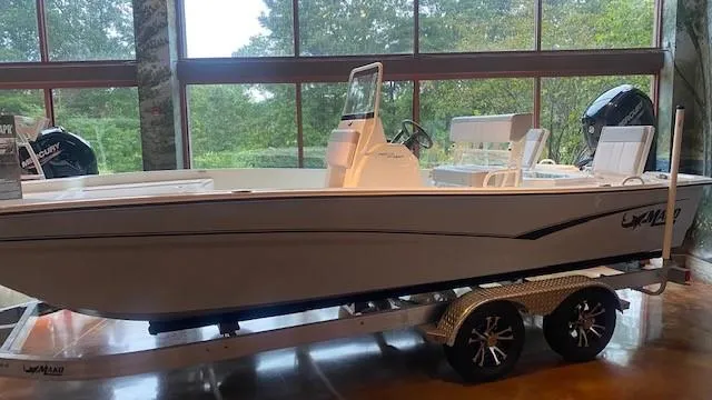 Slide: The Image of 2023 Mako Pro Skiff 19 CC boat on a trailer in a showroom. - 1