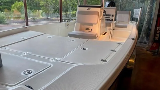 Slide: The Image of 2023 Mako Pro Skiff 19 CC boat on display in a showroom. - 3