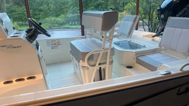 Slide: The Image of 2023 Mako Pro Skiff 19 CC boat interior with seating and storage compartments. - 4