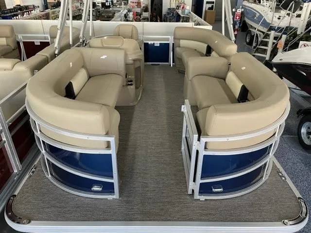 Slide: The Image of 2023 Starcraft LX 16 R pontoon boat with beige seating and blue accents. - 5