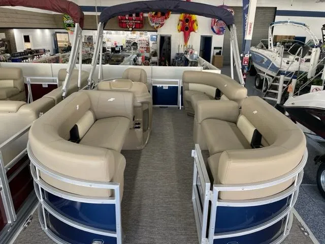 Slide: The Image of 2023 Starcraft LX 16 R pontoon boat with beige seating in showroom. - 6