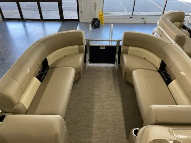 Slide: The Image of 2023 Starcraft LX 16 R pontoon boat interior with beige seating and cup holders. - 7