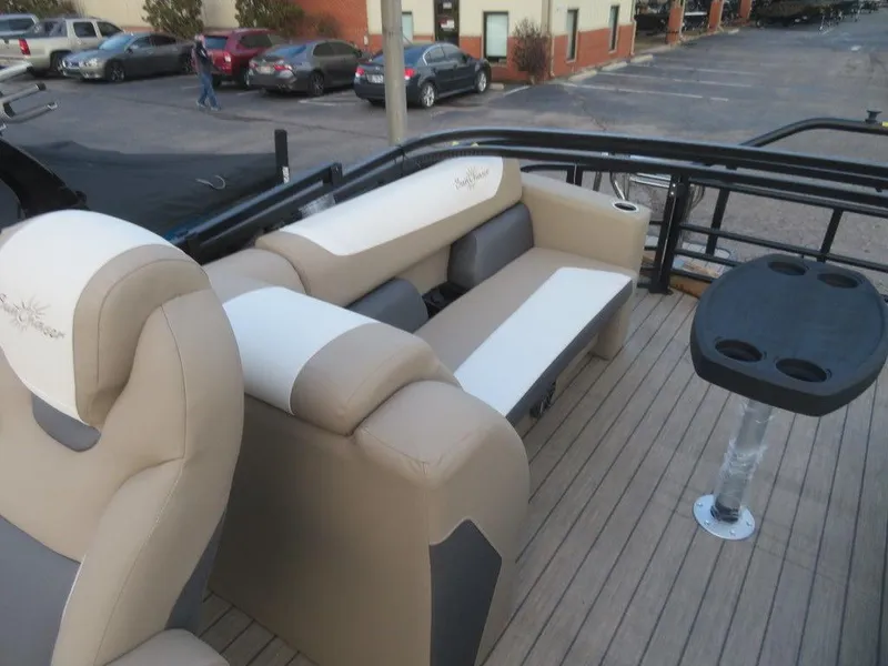 Slide: The Image of 2023 SunChaser Eclipse 25 LR DH pontoon boat interior with beige seating and table. - 24