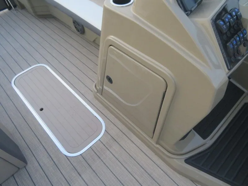 Slide: The Image of 2023 SunChaser Eclipse 25 LR DH boat interior with storage compartment and control panel. - 9