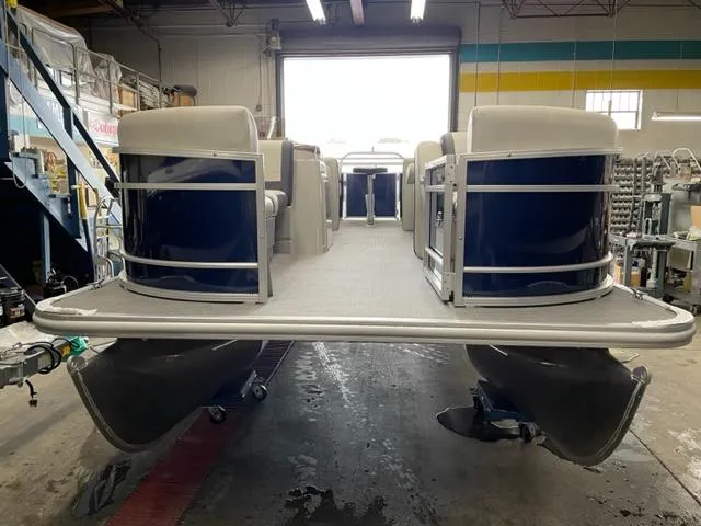 Slide: The Image of 2023 Starcraft EX 22 R pontoon boat in a workshop. - 2