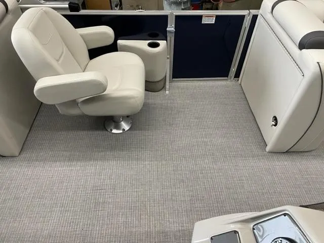 Slide: The Image of 2023 Starcraft EX 22 R boat interior with white captain's chair and gray flooring. - 20