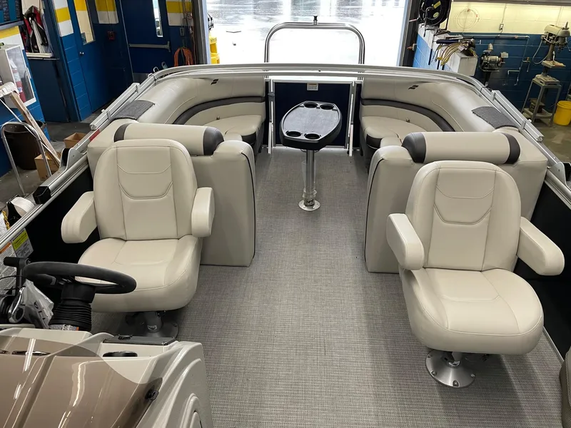 Slide: The Image of 2023 Starcraft EX 22 R pontoon boat interior with plush seating and table. - 22