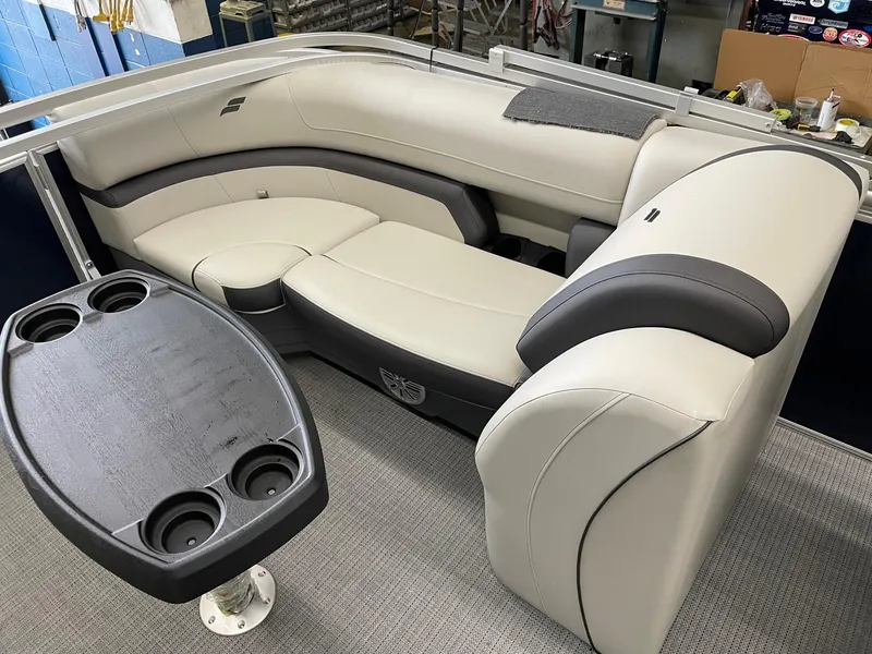 Slide: The Image of 2023 Starcraft EX 22 R pontoon boat interior with plush seating and cupholder table. - 23