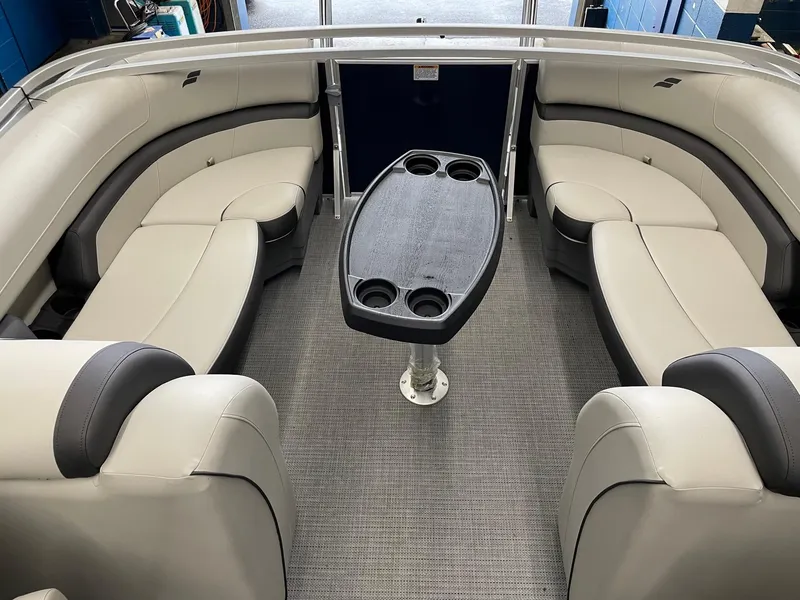 Slide: The Image of 2023 Starcraft EX 22 R pontoon boat interior with plush seating and central table. - 24