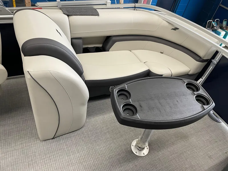 Slide: The Image of 2023 Starcraft EX 22 R boat interior with plush seating and a cupholder table. - 25