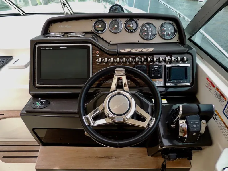 Slide: The Image of 2016 Sea Ray 350 Sundancer helm with steering wheel, gauges, and navigation controls. - 5