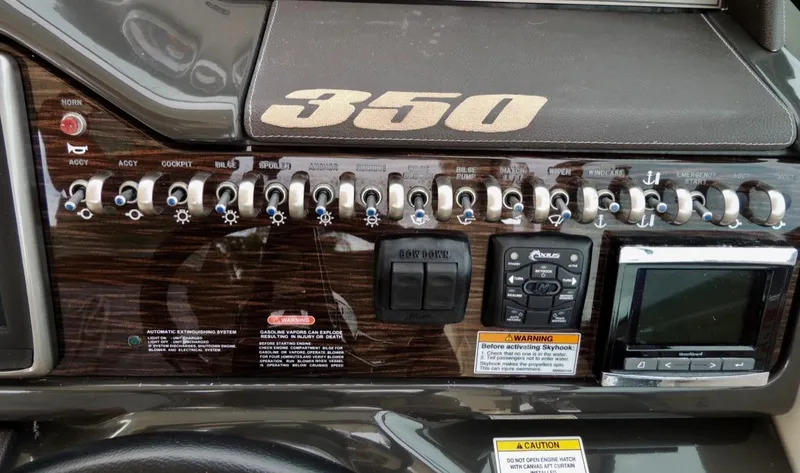 Slide: The Image of Control panel of a 2016 Sea Ray 350 Sundancer boat with various switches and displays. - 7