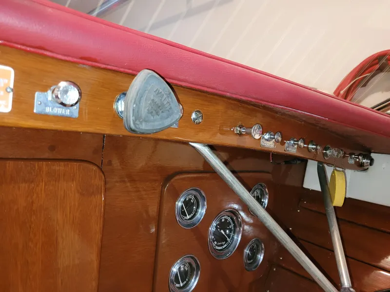 Slide: The Image of 1953 Chris-Craft HOLIDAY 24 dashboard with vintage controls and red upholstery. - 24