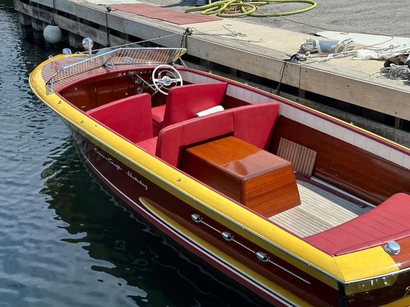Slide: The Image of 1953 Chris-Craft HOLIDAY 24 classic wooden boat docked, featuring red seats and yellow trim. - 3
