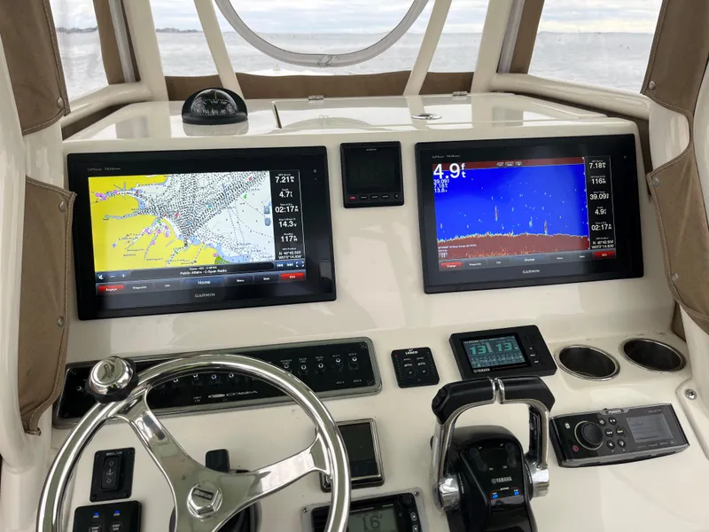 Slide: The Image of Cobia 296 CC 2016 boat dashboard with navigation and fishfinder screens. - 10