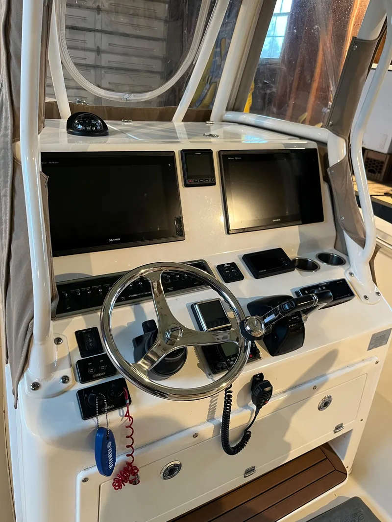 Slide: The Image of 2016 Cobia 296 CC boat helm with dual screens and steering wheel. - 2