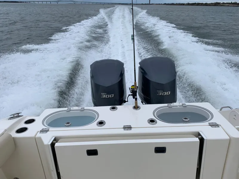 Slide: The Image of 2016 Cobia 296 CC boat with twin 300 HP engines cruising on water. - 7