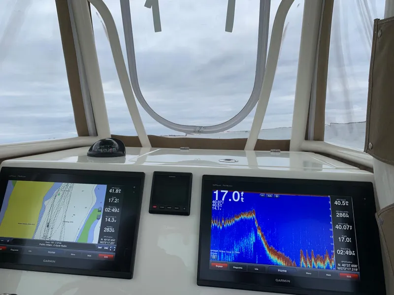Slide: The Image of 2016 Cobia 296 CC boat dashboard with navigation and fish finder screens. - 9