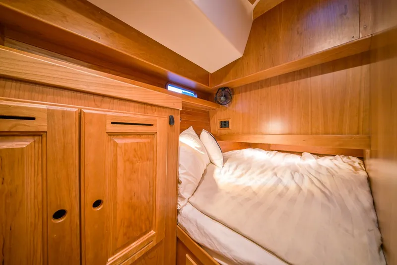 Slide: The Image of Cozy wooden cabin interior of 2025 Tartan 455 yacht with bed and storage cabinets. - 21