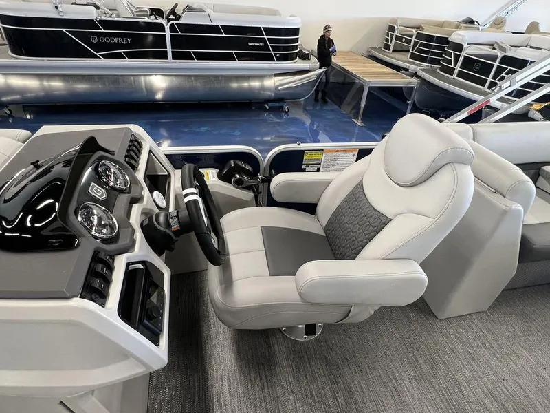 Slide: The Image of 2023 Godfrey SW 2286 MT boat interior with steering console and captain's chair. - 7
