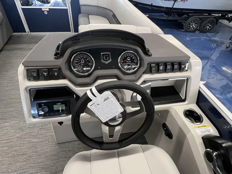 Slide: The Image of 2023 Godfrey SW 2286 MT boat dashboard with steering wheel and control panel. - 8