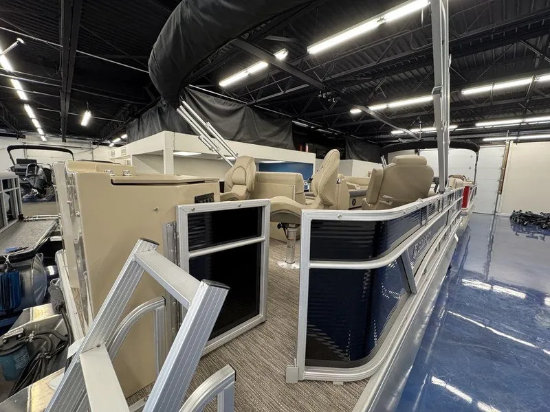 Slide: The Image of 2023 Godfrey SW 2286 FS pontoon boat displayed indoors with beige seating. - 5
