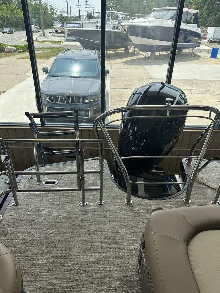 Slide: The Image of View from the deck of a 2023 Godfrey MC 255 SFL boat, showing a parked car and other boats. - 2