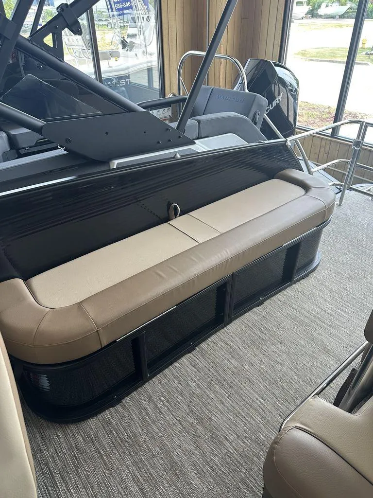 Slide: The Image of 2023 Godfrey MC 255 SFL boat interior with tan seating and Mercury engine. - 4