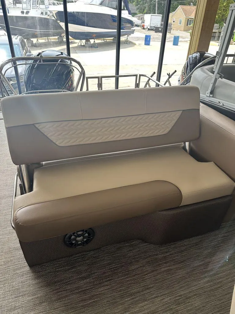 Slide: The Image of 2023 Godfrey MC 255 SFL boat interior seating with beige upholstery and speaker. - 5