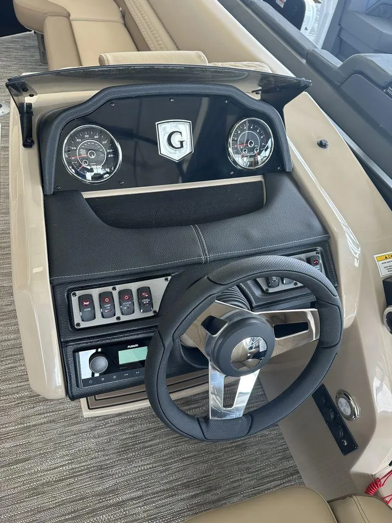 Slide: The Image of 2023 Godfrey MC 255 SFL boat dashboard with steering wheel and control panel. - 6