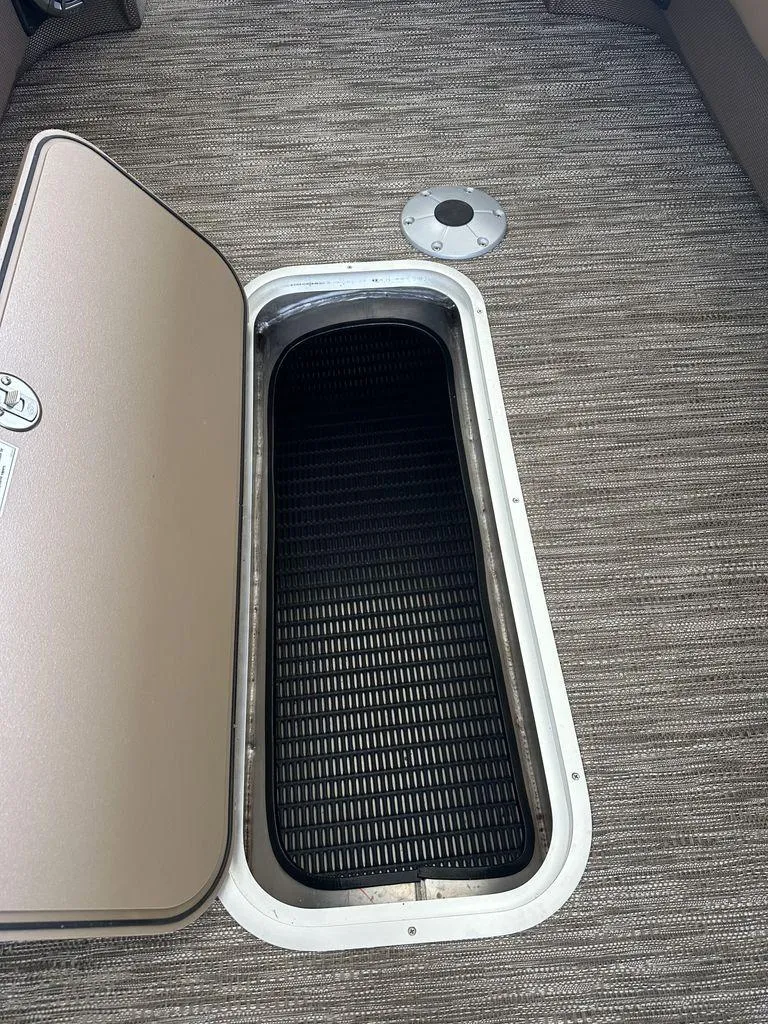 Slide: The Image of Open storage compartment on 2023 Godfrey MC 255 SFL boat with carpeted flooring. - 8