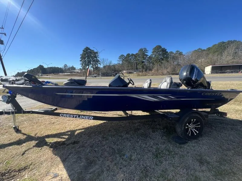 Slide: The Image of 2023 Crestliner XF 179 fishing boat on a trailer, parked on grass. - 2
