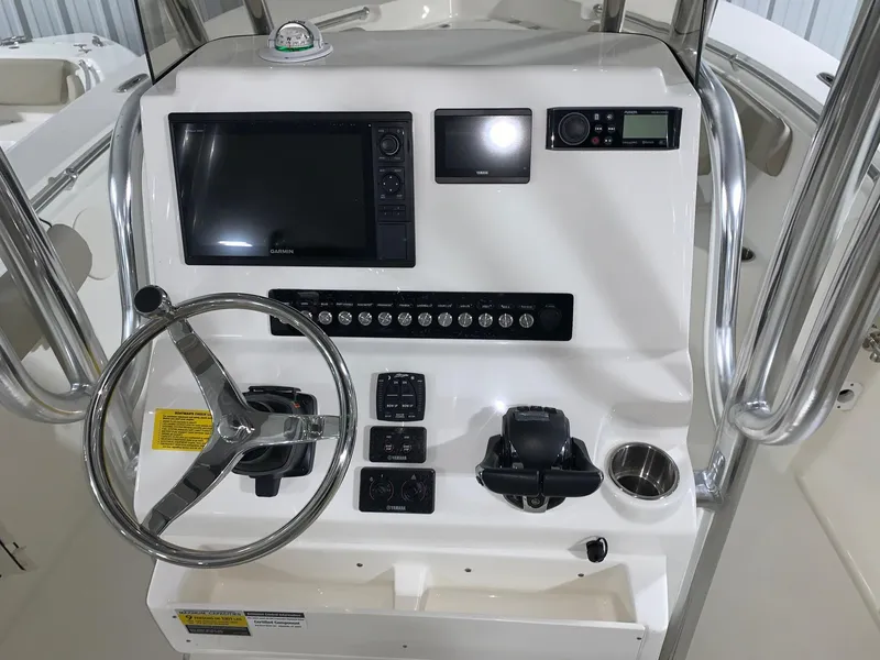 Slide: The Image of 2024 Key West 244 Center Console boat dashboard with steering wheel, navigation system, and controls. - 11