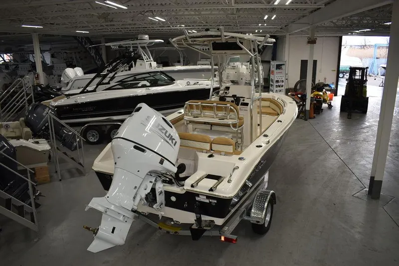 Slide: The Image of 2023 Sea Chaser 20 HFC boat in showroom, featuring Suzuki outboard motor. - 2