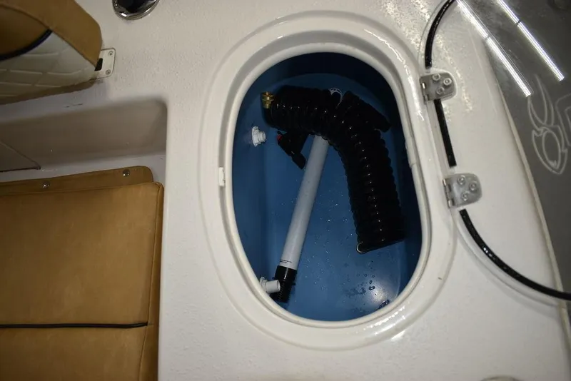 Slide: The Image of 2023 Sea Chaser 20 HFC boat storage compartment with hose. - 21