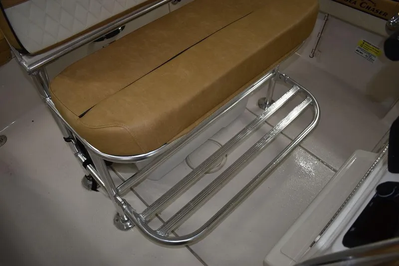 Slide: The Image of 2023 Sea Chaser 20 HFC boat interior with tan cushioned seating and metal footrest. - 26