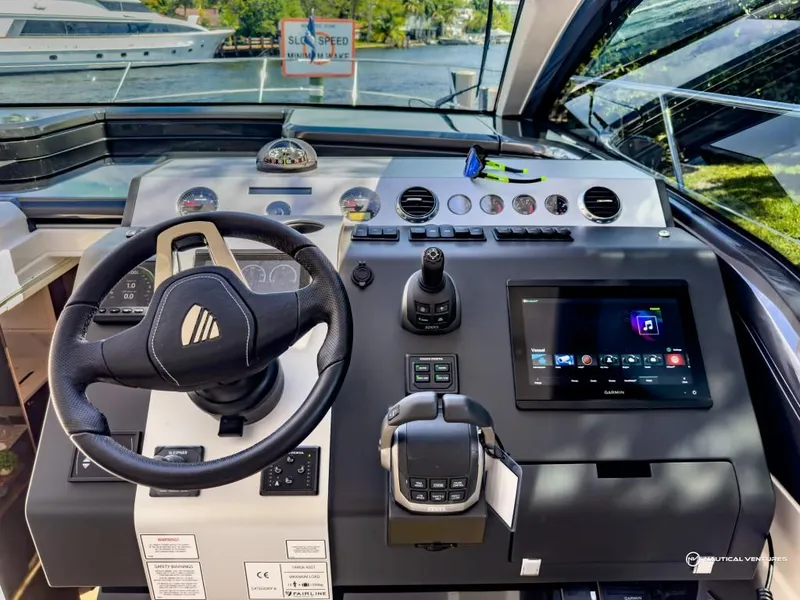 Slide: The Image of Control panel of a 2023 Fairline Targa 45 Open yacht with steering wheel and touchscreen display. - 13