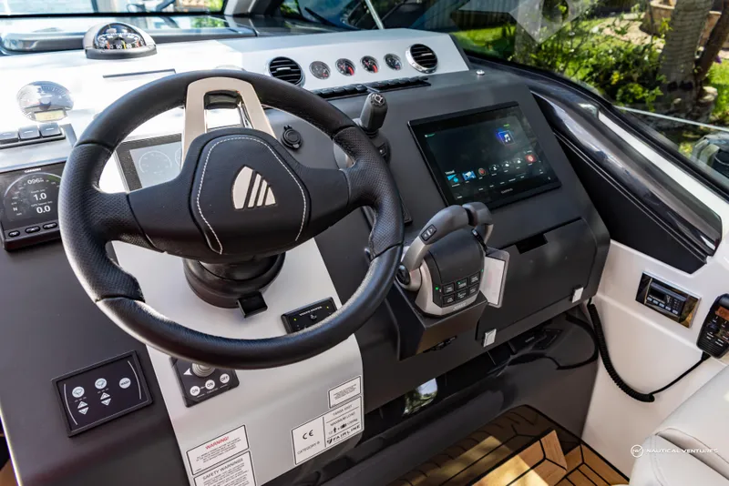 Slide: The Image of 2023 Fairline Targa 45 Open yacht helm with steering wheel and touchscreen controls. - 14