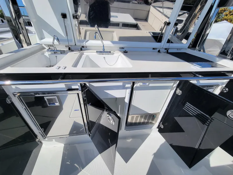 Slide: The Image of 2024 Jeanneau Leader 12.5 WA boat kitchen with sink, storage, and appliances. - 19